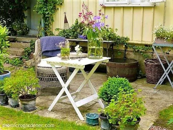 A cosy setting in a small quaint garden surrounded with pots 